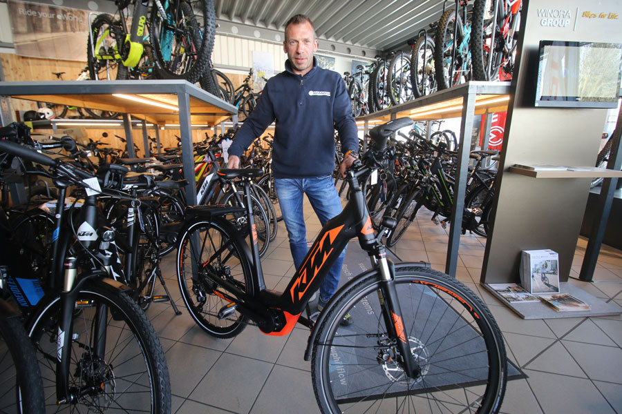 fahrrad-weidemann-marc-weidemann-mit-zweirad Marc Weidemann von Fahrrad Weidemann am Bodensee im Ladengeschäft mit E-Bike